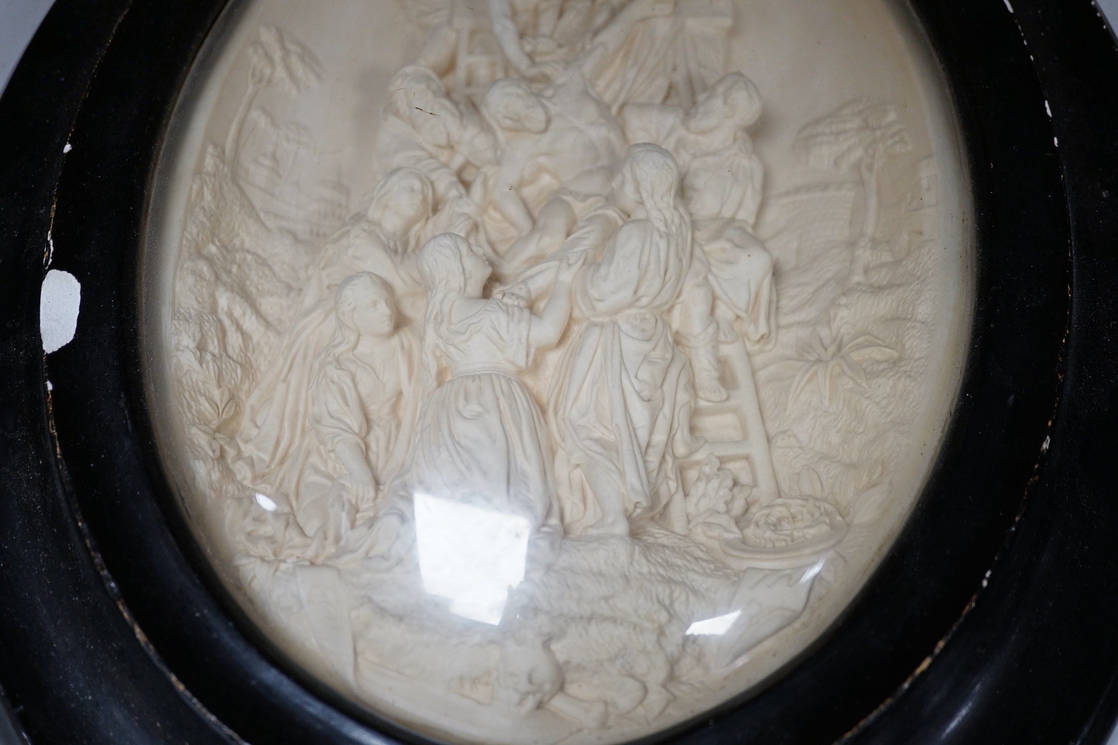 A pair of framed plaster ovals of the Madonna and Child with John the Baptist and the 'Descent from the Cross' 41x33cm